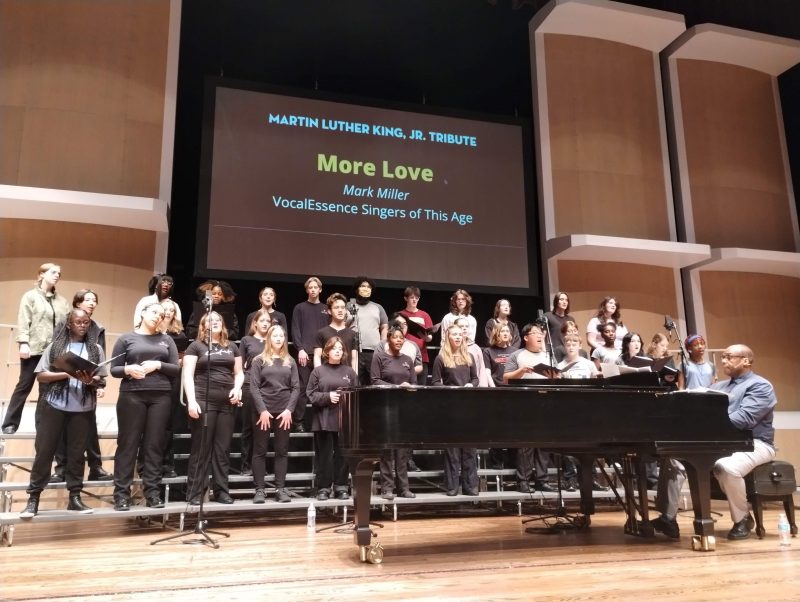 VocalEssence Cantantes de esta época de pie sobre gradas con G. Phillip Shoultz, III al piano actuando en el Concierto Tributo a Martin Luther King, Jr. Crédito de la foto: Rhiannon Fiskradatz.