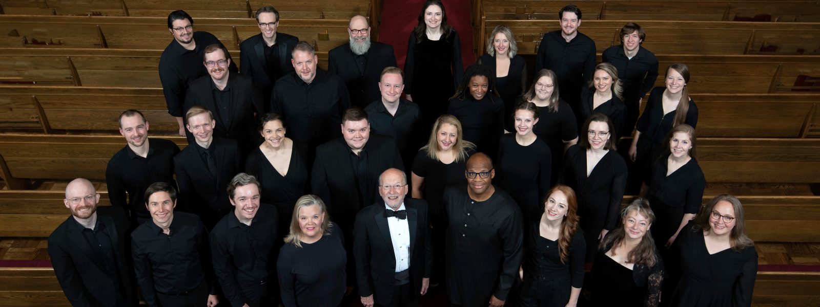 VocalEssence Ensemble Singers wearing black pose for a photo. Photo Credit: Bruce Silcox