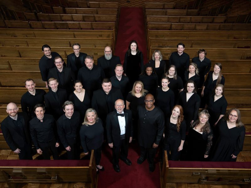VocalEssence Ensemble Singers wearing black pose for a photo. Photo Credit: Bruce Silcox