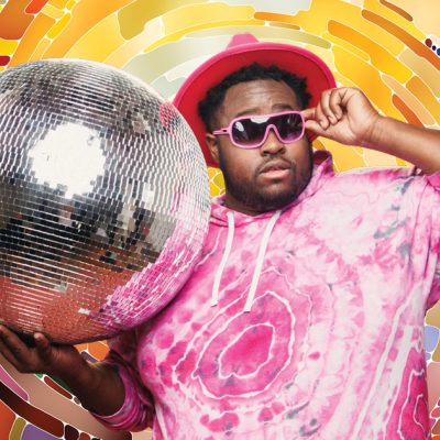 Hip-hop artist Nur-D, wearing a pink tie-dye shirt, pink hat, and pink sunglasses, holding a large disco ball, on a multi-colored background that imitates the disco ball design.