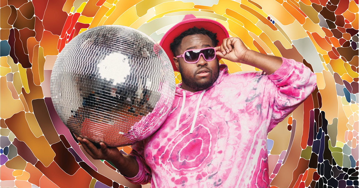 Hip-hop artist Nur-D, wearing a pink tie-dye shirt, pink hat, and pink sunglasses, holding a large disco ball, on a multi-colored background that imitates the disco ball design.