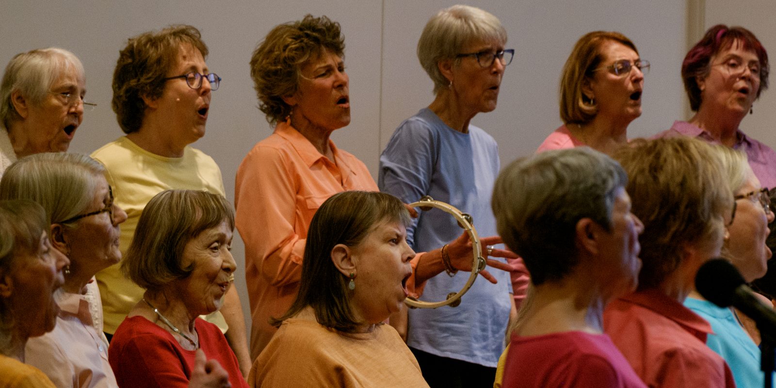 Vintage Voices Singers performing wearing pastel colored tops and black pants. Photo credit: Ethan Kellum Johnson
