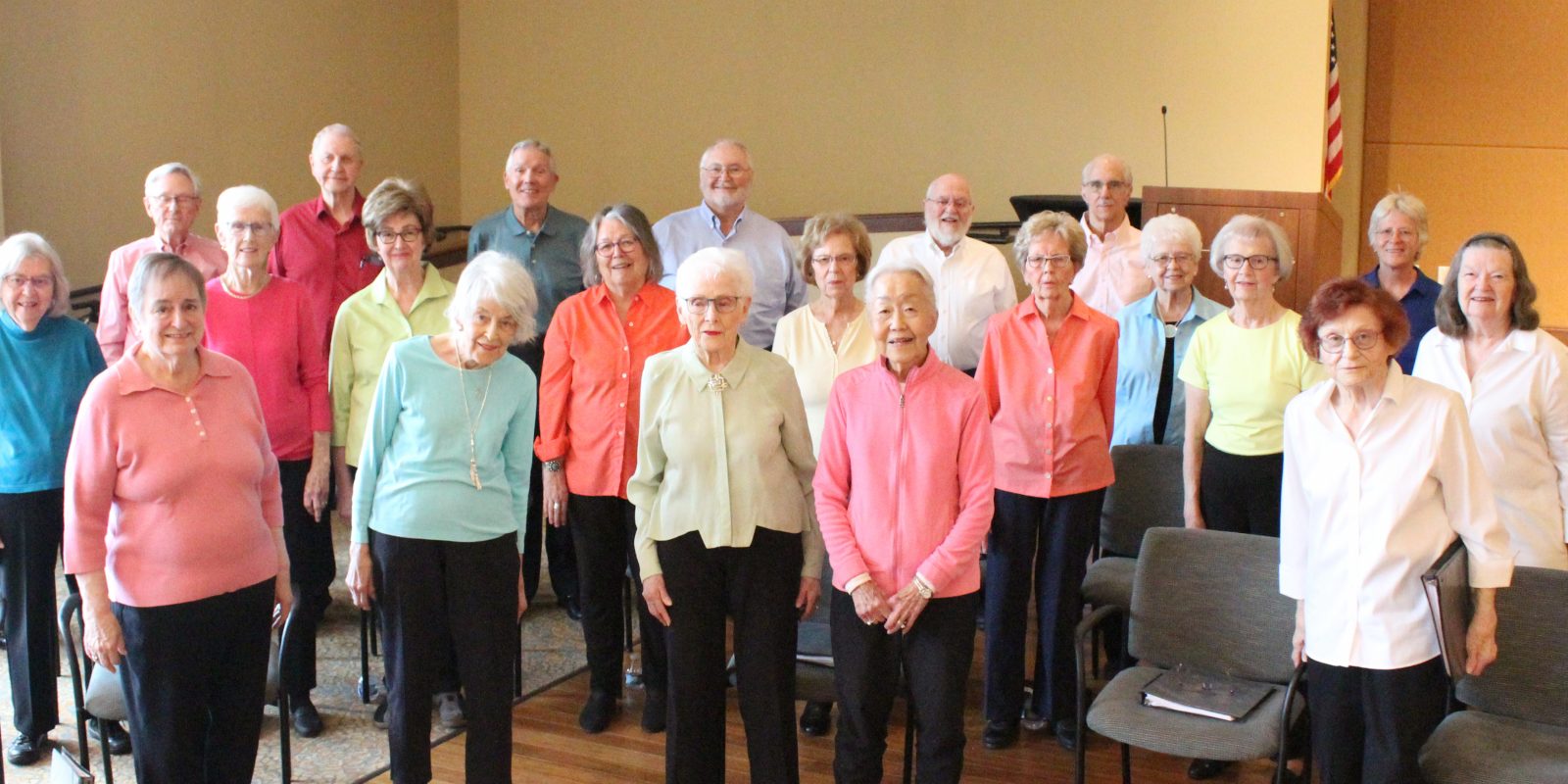 Vintage Voices Singers pose for a group photo wearing pastel colored tops and black pants. Photo credit: Tonia Swennes