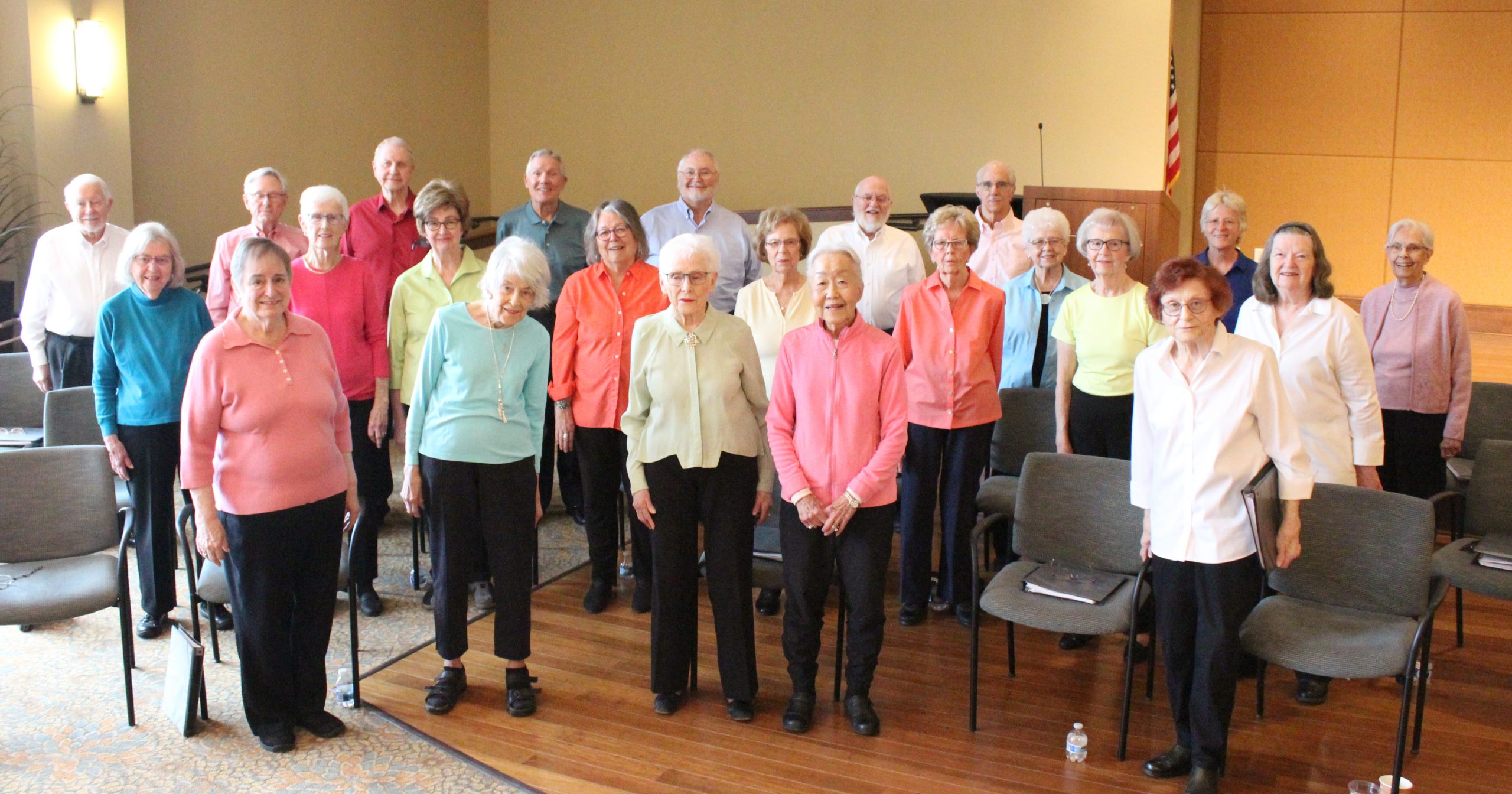 Vintage Voices Singers pose for a group photo wearing pastel colored tops and black pants. Photo credit: Tonia Swennes