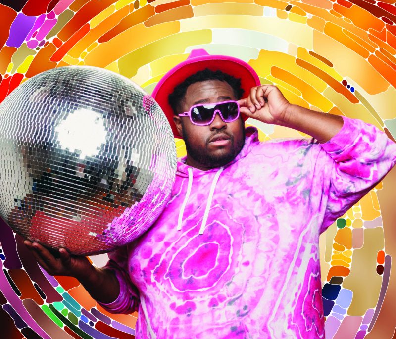 NUR-D spoken word artist, holding disco ball, WITNESS school program